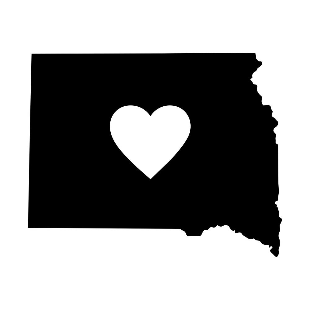 Solid black South Dakota state map sticker with a white heart shape cut out of the center